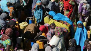 Women gather to collect water at a motorised borehole at the Muna Internally displace people camp in Maiduguri, Nigeria