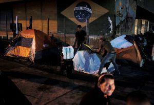 Venezuelan men erect their tent to sleep along the street as they wait to show their passports or identity cards next day at the Pacaraima border control